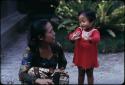 Woman kneeling next to a child