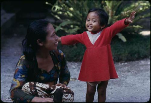 Woman kneeling next to a child