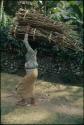 Person carrying bundles on their head