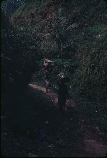 People walking down a road carrying baskets