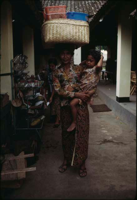 Person carrying a baby and a basket