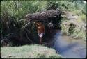 Person carrying a bundle of sticks