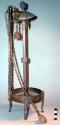 Iron oil lamp standing on four legs, sharp object and spoon +