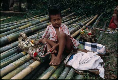 Child sitting on bamboo poles