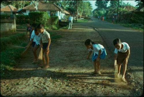 Children sweeping road