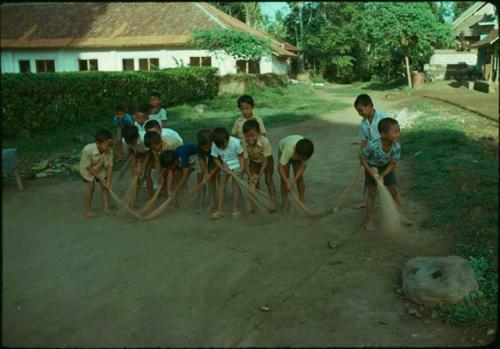 Children sweeping road