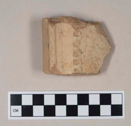 Molded, coarse red bodied earthenware rim sherd, with buff slip