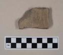 Coarse gray bodied earthenware rim sherd, with buff slip