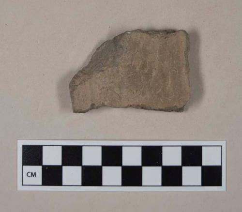 Coarse gray bodied earthenware rim sherd, with buff slip