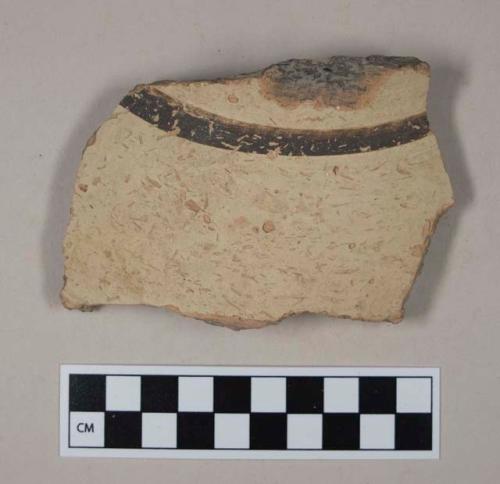 Coarse red bodied earthenware body sherd, with buff slip and brown slipped stripes, reduced core