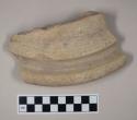 Molded, coarse buff bodied earthenware rim sherd, unslipped