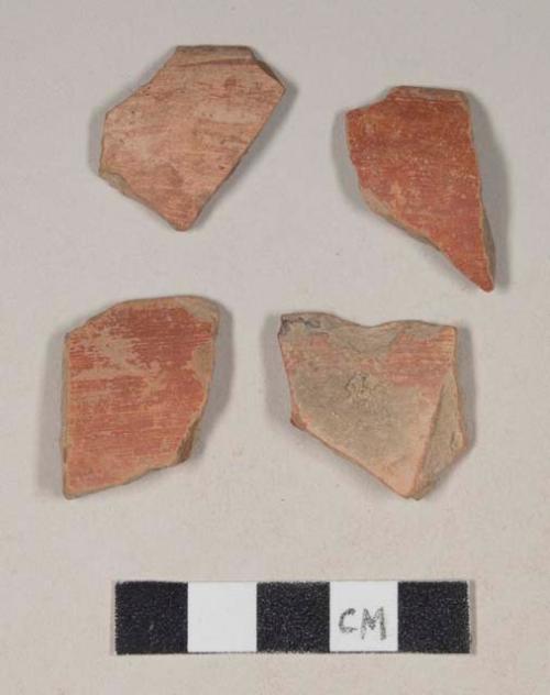 Red bodied earthenware rim sherd, with red slip and black slipped stripes, wheel thrown
