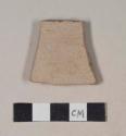 Coarse buff bodied earthenware body sherd, unslipped