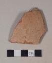 Coarse red bodied earthenware rim sherd, with buff slip, reduced core