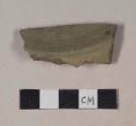 Gray bodied earthenware base sherd, with green slip, wheel thrown