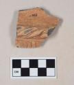Red bodied earthenware body sherd, with red slipped exterior and brown slipped interior, reduced core, molded and incised design