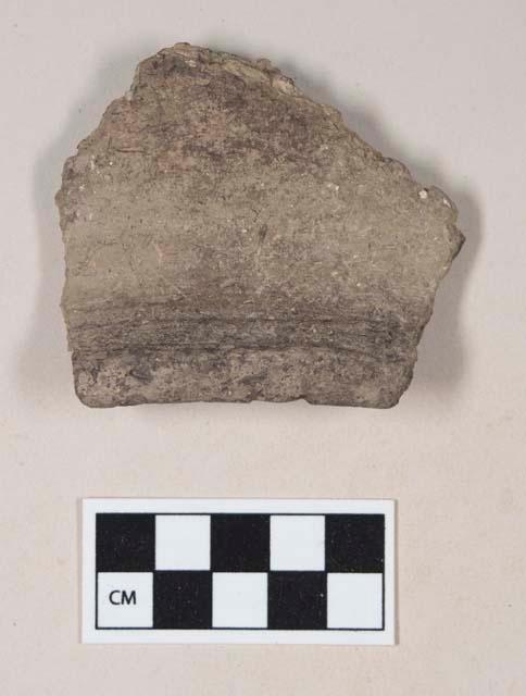 Coarse gray bodied earthenware rim sherd, unslipped, reduced core