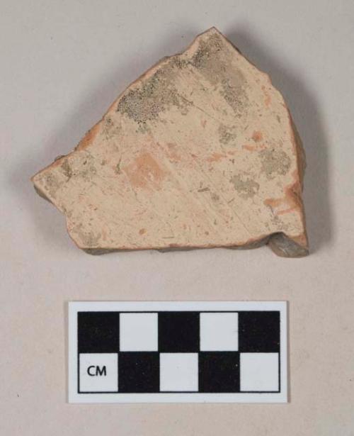 Coarse red bodied earthenware body sherd, with buff slip, reduced core