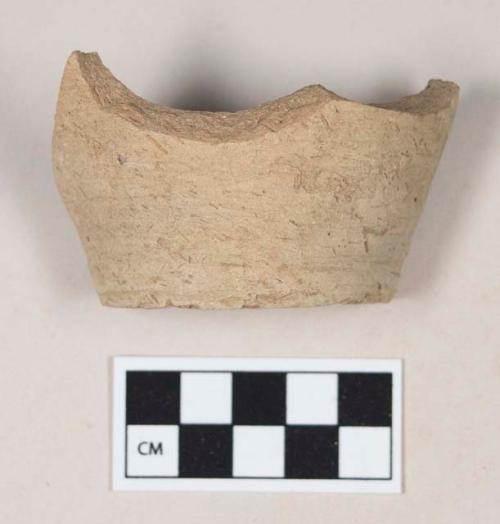 Coarse brown bodied earthenware base sherd, with buff slip
