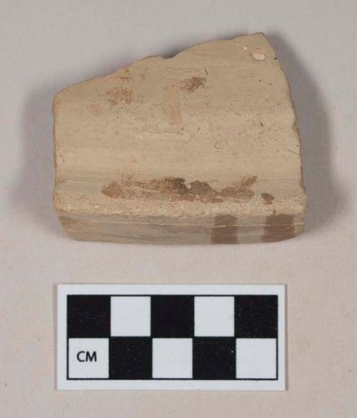 Coarse red bodied earthenware rim sherd, with buff slip and red slipped stripes