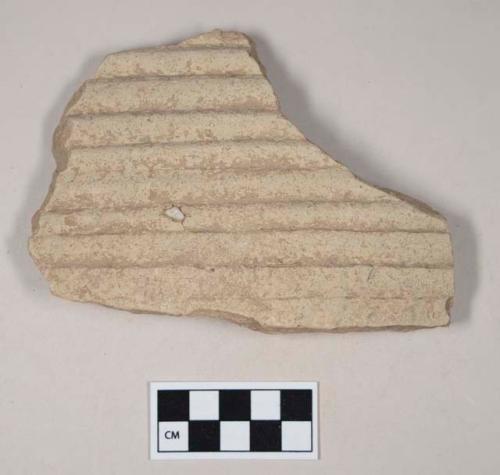 Coarse red bodied earthenware body sherd, molded, with buff slip