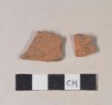 Unglazed, undecorated redware body sherds; two sherds crossmend