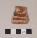 Slip decorated, lead glazed redware rim sherd