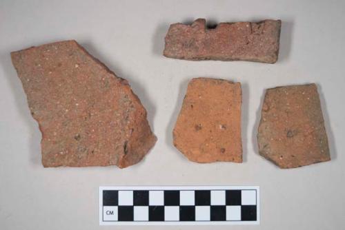 Redware roof tile fragments, one with nail hole; two fragments crossmend