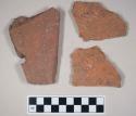 Redware roof tile fragments, one with nail hole; two fragments crossmend