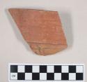 Rim potsherd - red with relief decoration