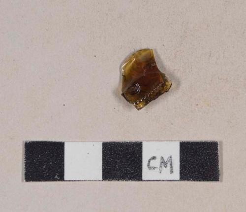 Molded and embossed amber bottle glass fragment