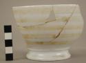 Part of white china bowl with yellow horizontal stripes; restored