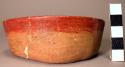 Restored flat-bottomed low sided pottery bowl-2 pellets of clay in bottom & radi