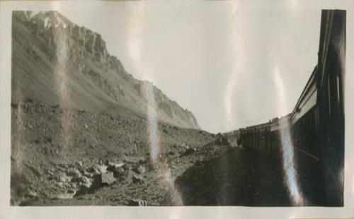 Train passing rocky hills