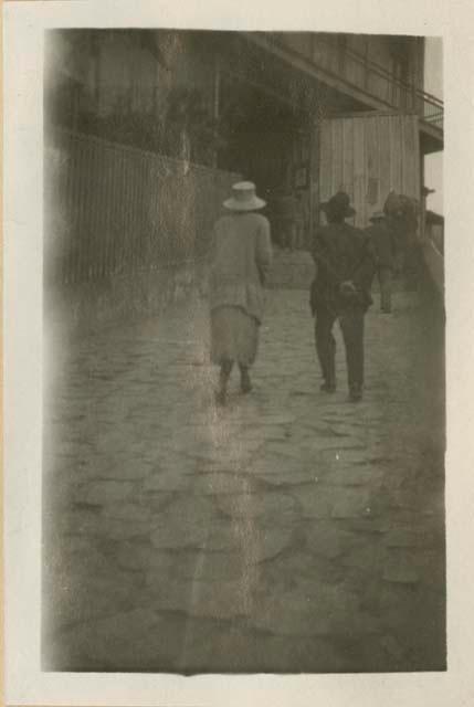 Two people walking up a street