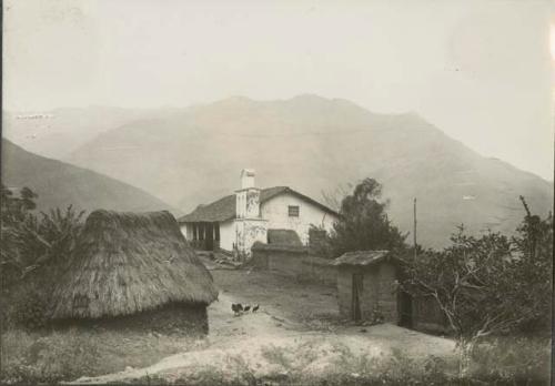 A few buildings, mountains in background