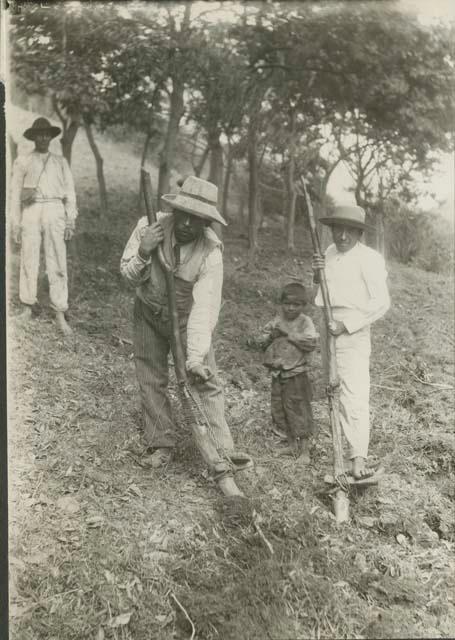 People ploughing with traditional tools