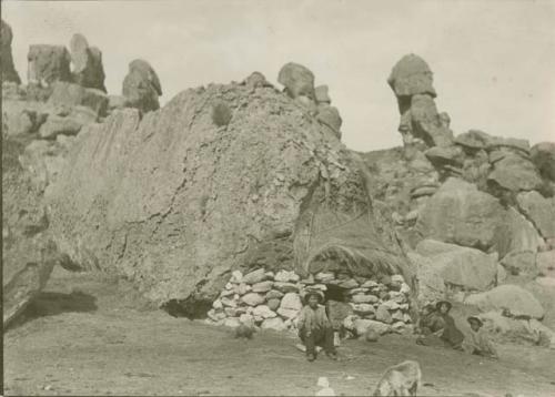 Man in front of structure built into rock