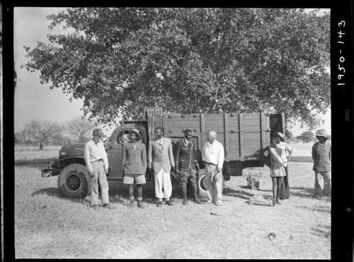 Chief Nehemiah and two sub-chiefs standing with John Marshall and Laurence Marshall  in front of a truck