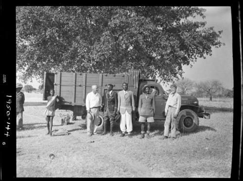 Chief Nehemiah and two sub-chiefs standing with John Marshall and Laurence Marshall in front of a truck