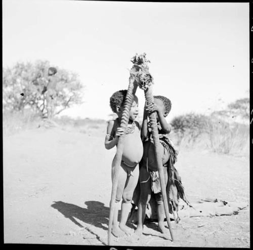 "Little ≠Gao" and Be (daughter of Bo) standing next to each other and holding gemsbok horns