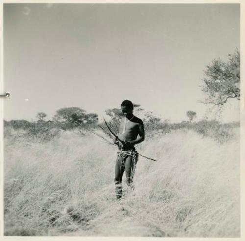 Man with bow and arrow walking in the grass