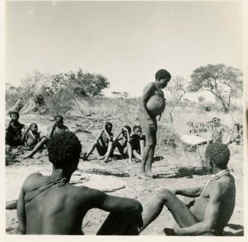 "Gao Hunchback" (leader of Band 11) standing, members of his band visiting at Gautscha sitting near him