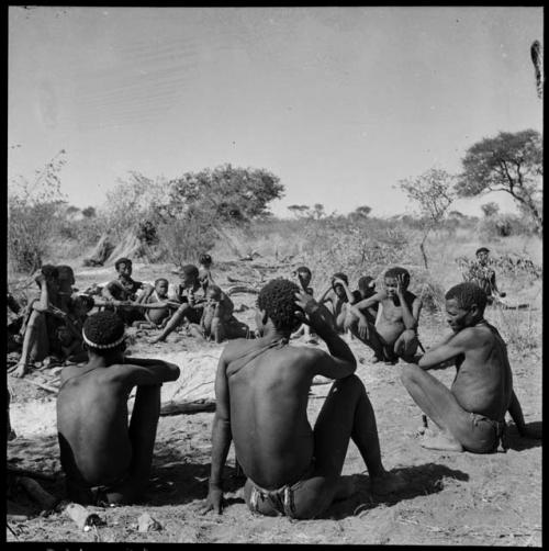 "Gao Hunchback" with his hand to his face, sitting with his band, his extended family