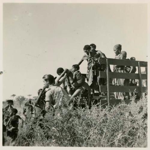 Women and children climbing down from an expedition truck, assisted by Heinrich Neumann and Ernst Westphal