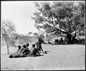 Two medicine men in deep trance (left), and people resting from a curing dance under a tree