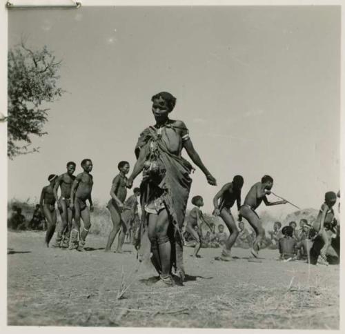 Woman dancing, with a group of people dancing behind her