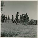 Group of people dancing, including a woman dancing with her baby (right) and //Ao (center)