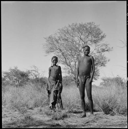 Bau (daughter of /Ti!kay, of Band 9) standing with her husband Tsamgao