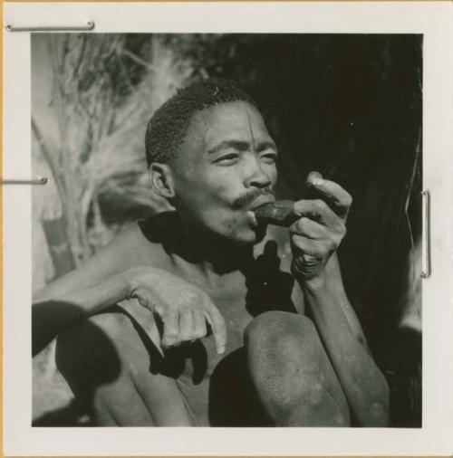 Brother of /Naoka and N!ai (wives of /Ti!kay) smoking a soapstone pipe